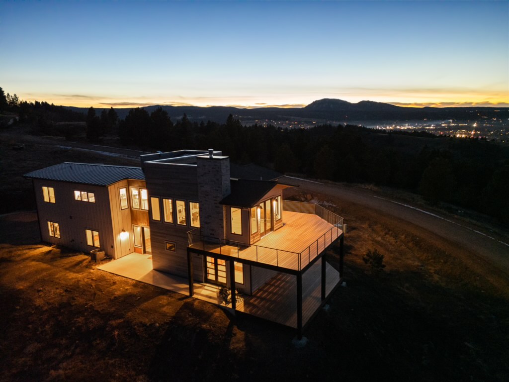 The deck and rear of the house glow at blue hour