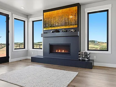 A gas fireplace sits beneath the aspen-grove canvas