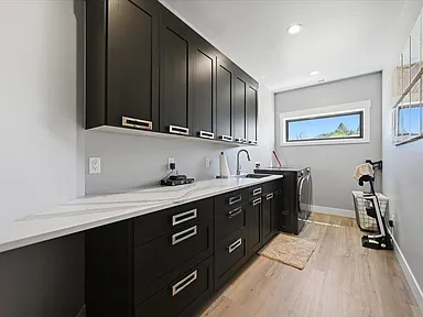 The laundry room has dark cabinetry