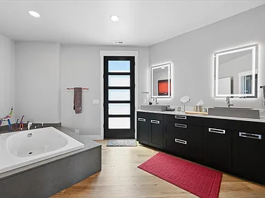 Primary bath — double vanity with lit mirrors