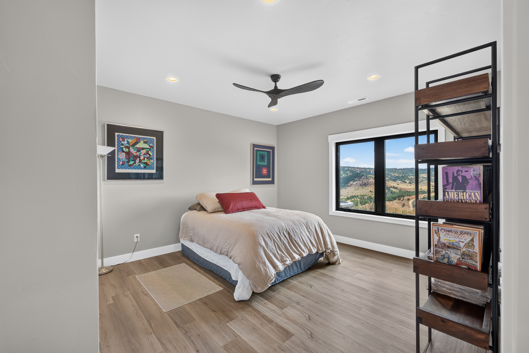A bedroom features framed quilt-pattern artwork