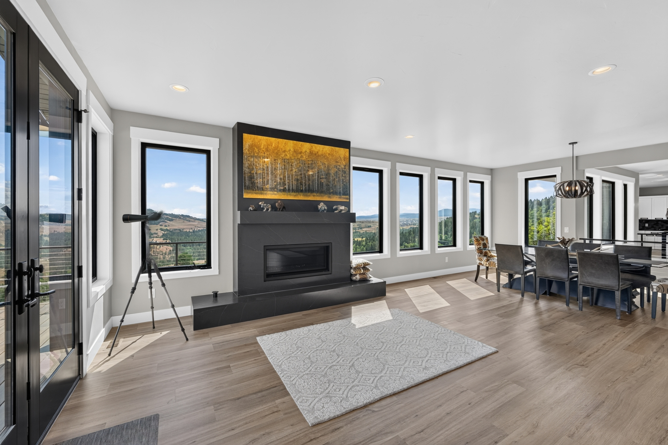 A linear fireplace beneath an aspen-grove painting anchors the room