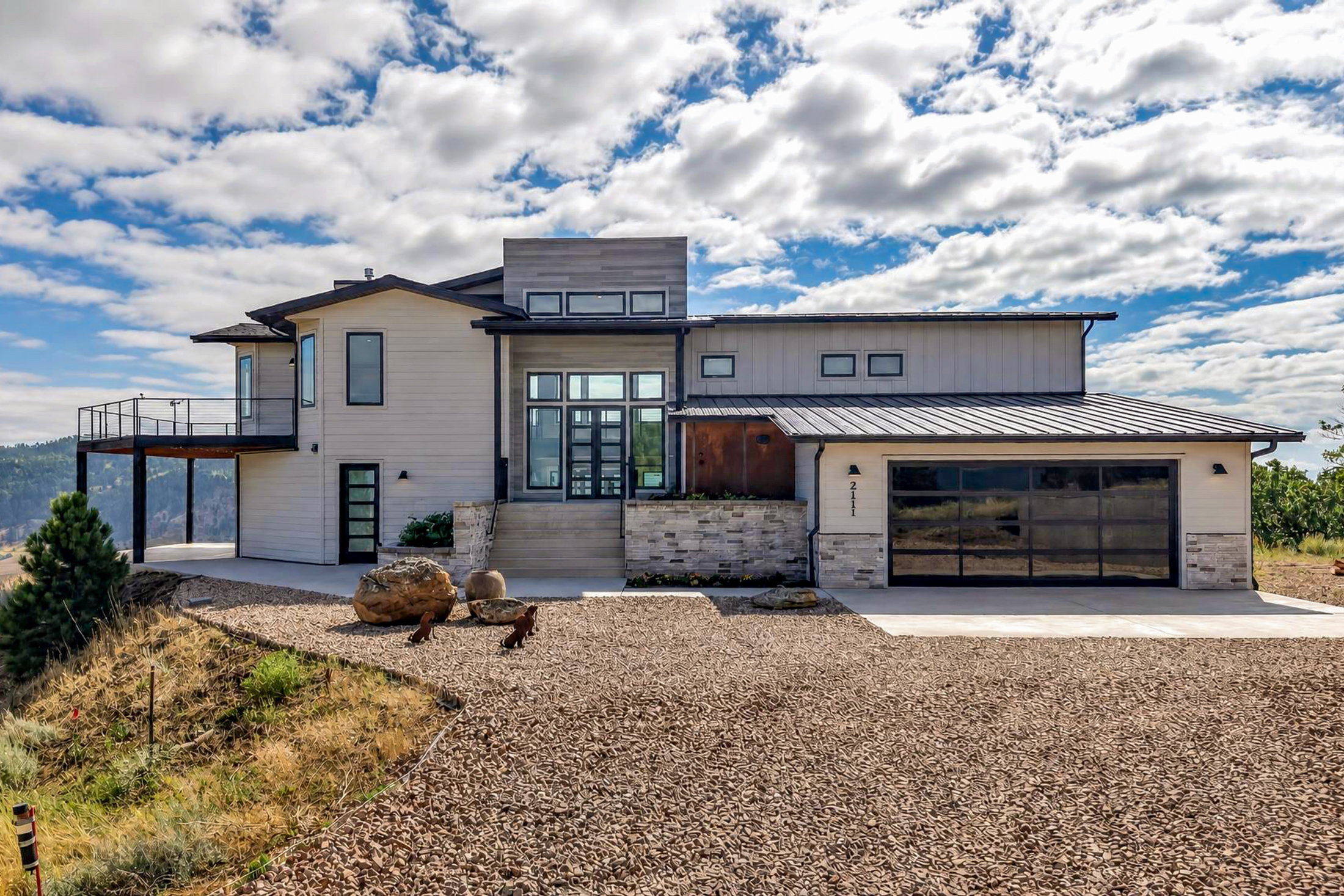 A wide gravel driveway leads to the front entry