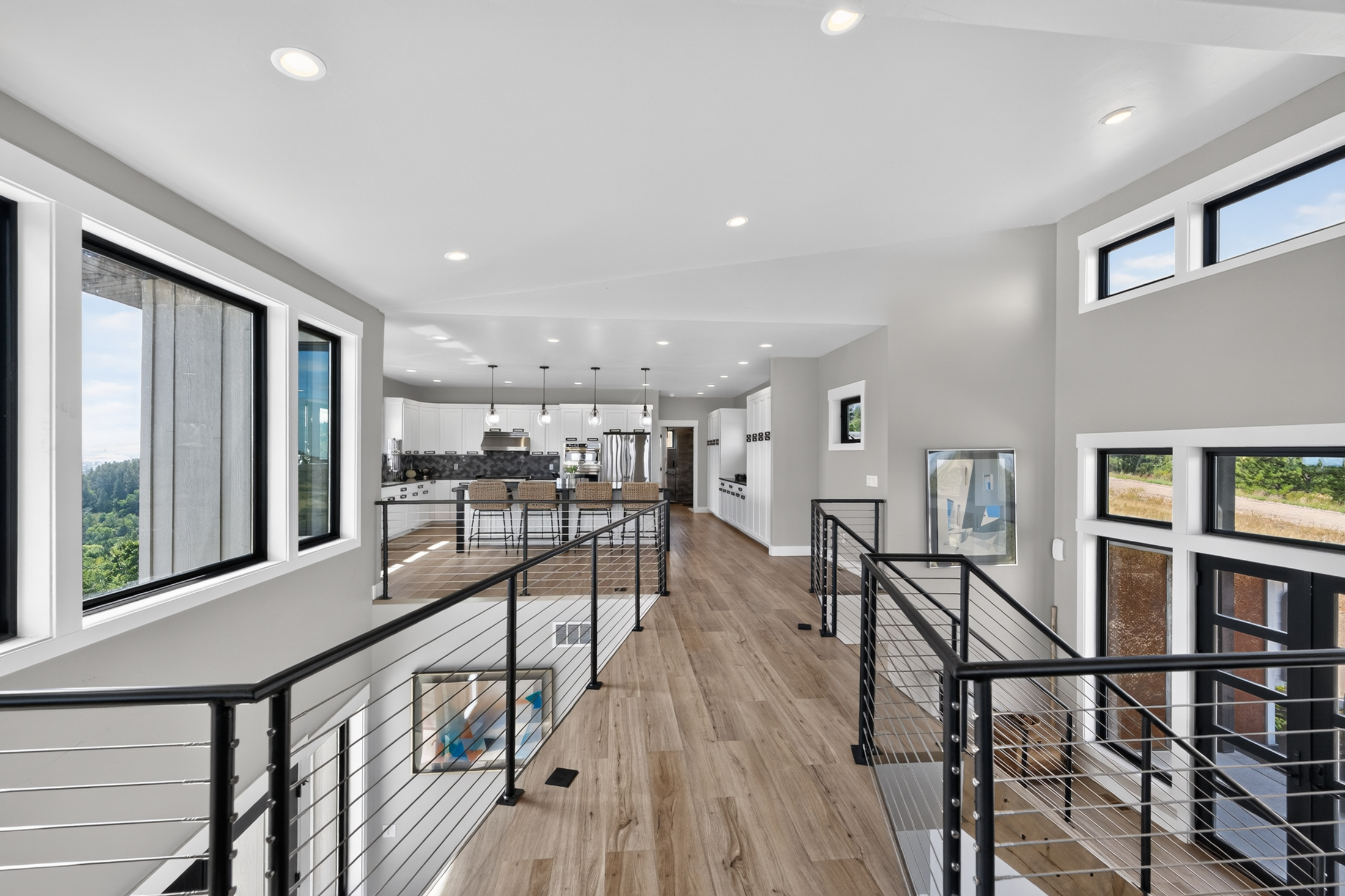 A large window at 2111 Vantage Circle frames a view of trees and hills beside the hallway leading to the kitchen.