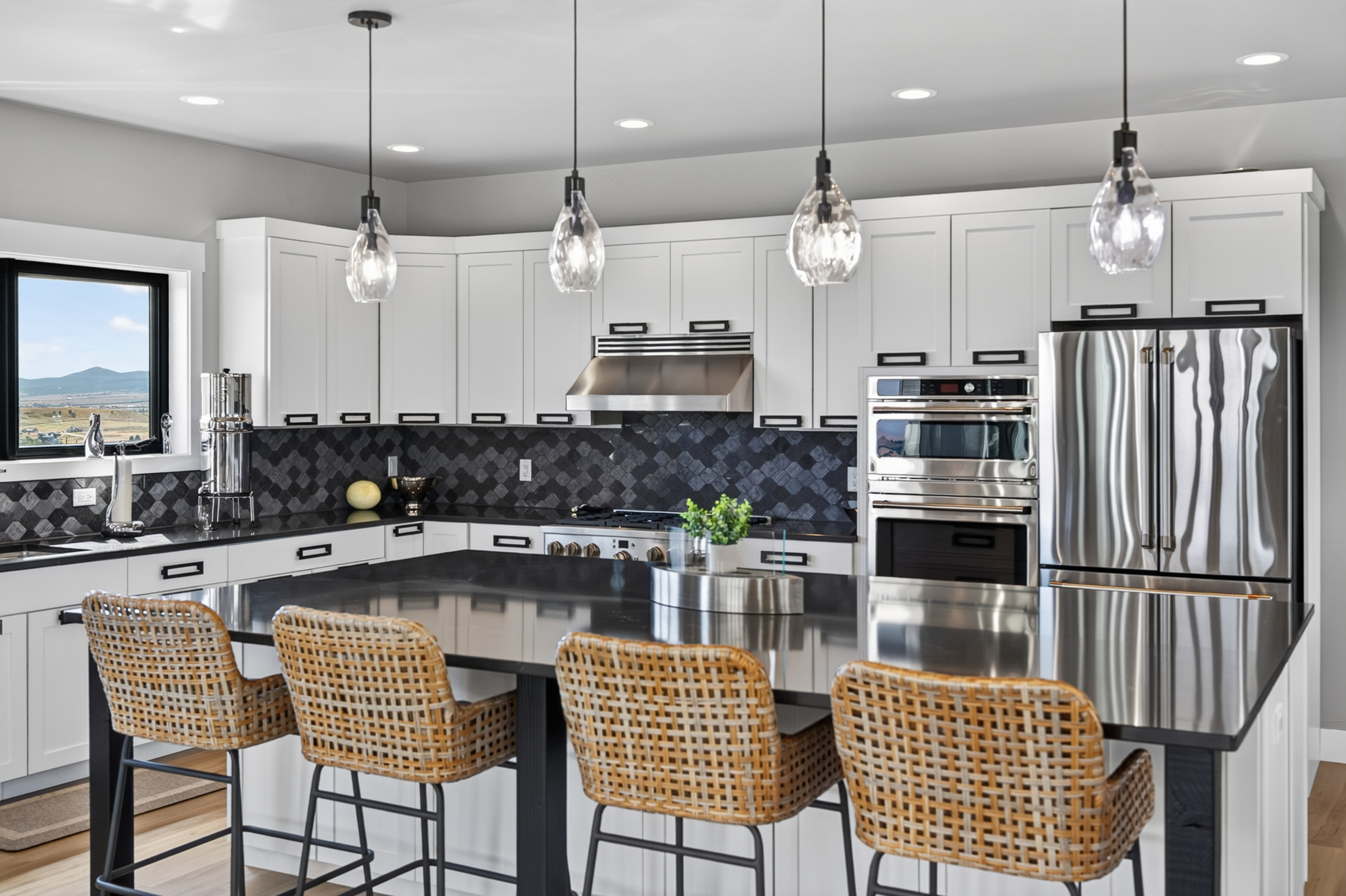 Stainless double ovens and a French-door refrigerator line the kitchen's corner at 2111 Vantage Circle, seen from the island seating.