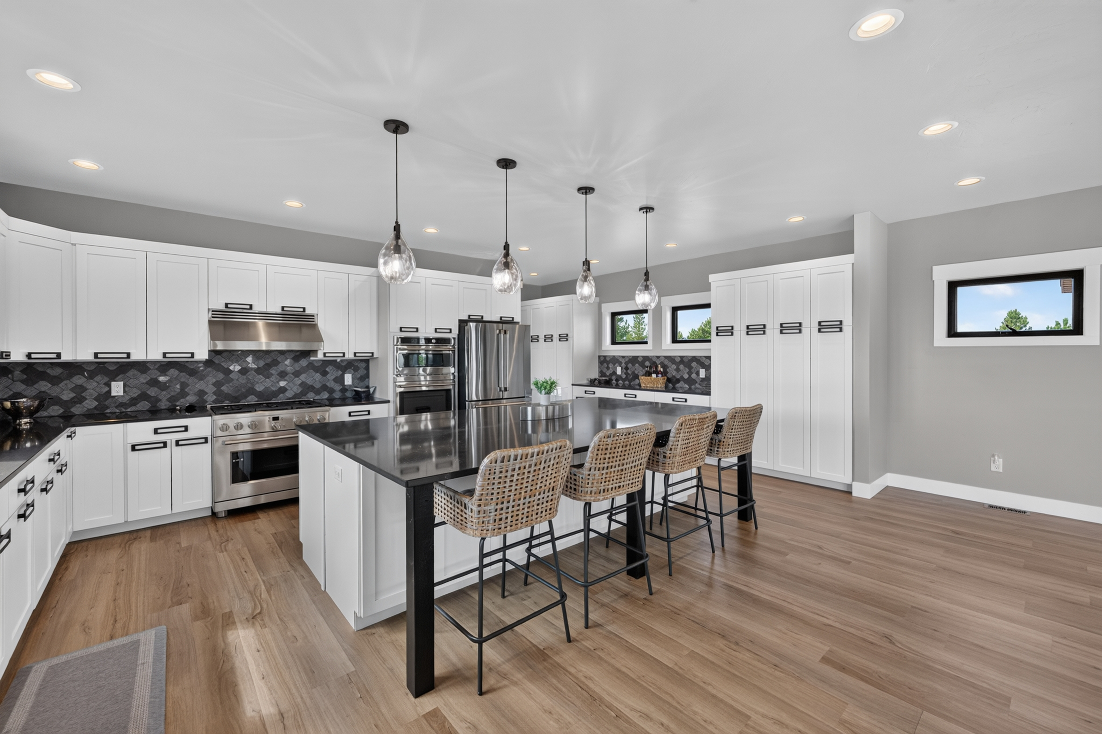 A gas range and dark tile backsplash sit beside floor-to-ceiling pantry cabinets in the kitchen at 2111 Vantage Circle.