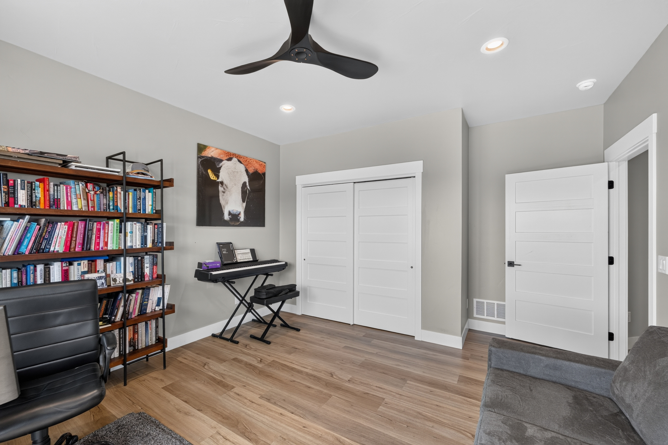 Another angle of the home office shows a loaded bookshelf